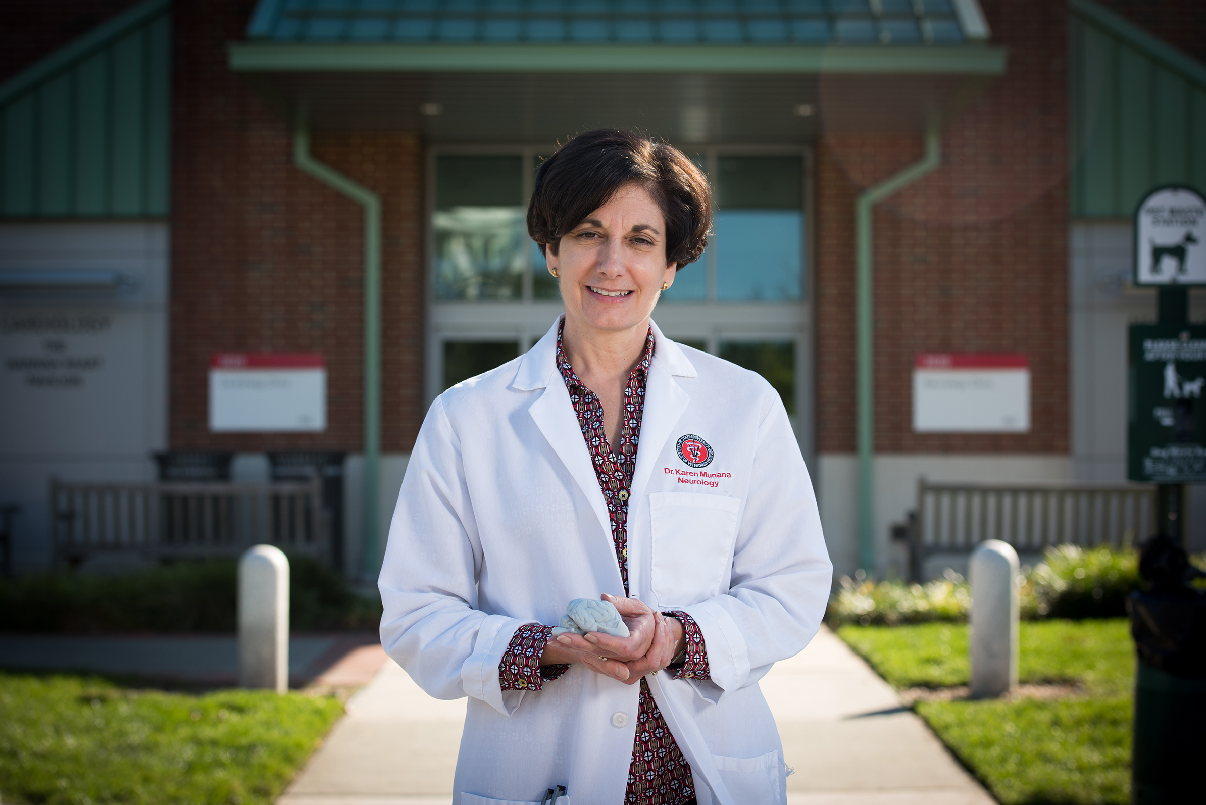 female doctor in white coat in front of building