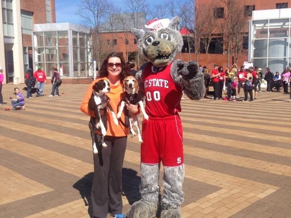 Wolf mascots stands with woman and dog