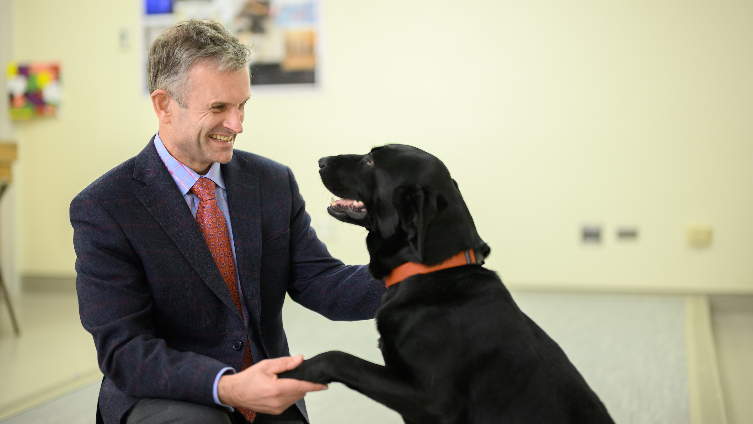 Dr. Lascelles hold paws with dog