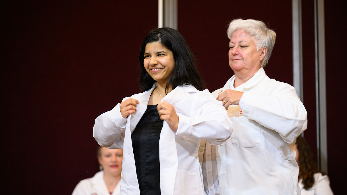 A student getting their white coat.