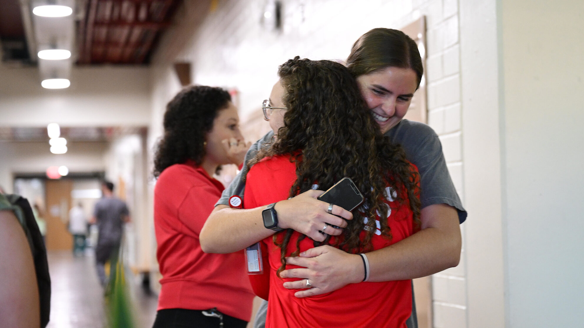 Two women embrace in the middle of a hallway at the NC State College of Veterinary Medicine.