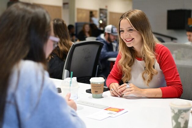 A veterinary student smiles at another student.