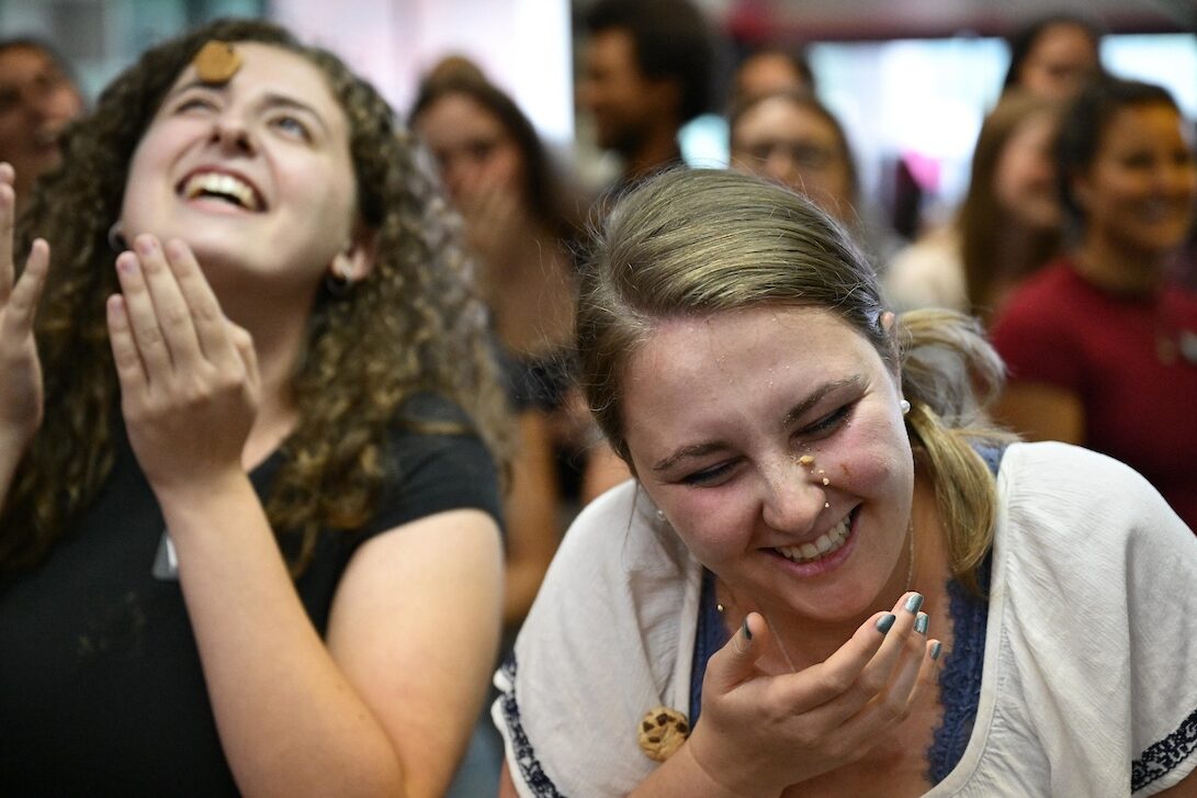 Students try to get cookies from their foreheads into their mouths.