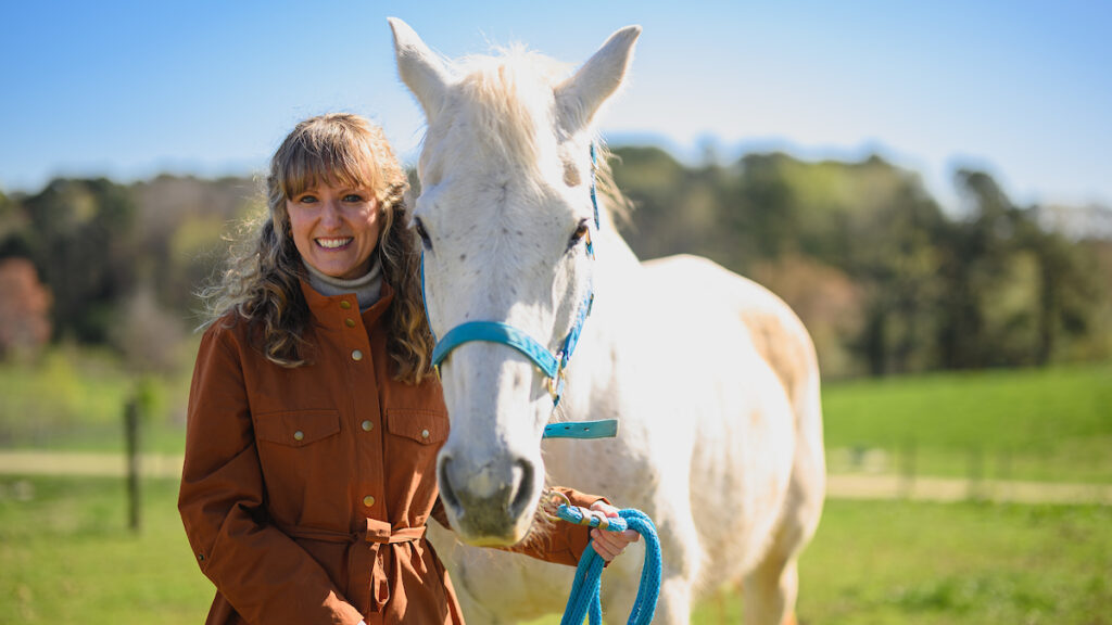 Dr. Katie Sheats with a white horse.