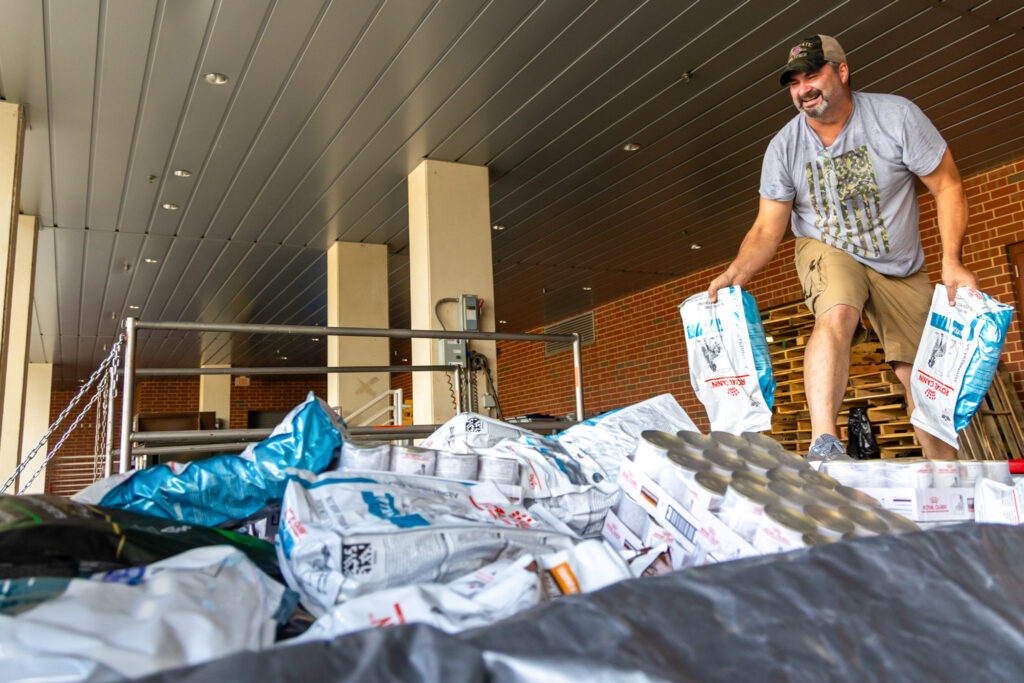 A person loading a truck with food.