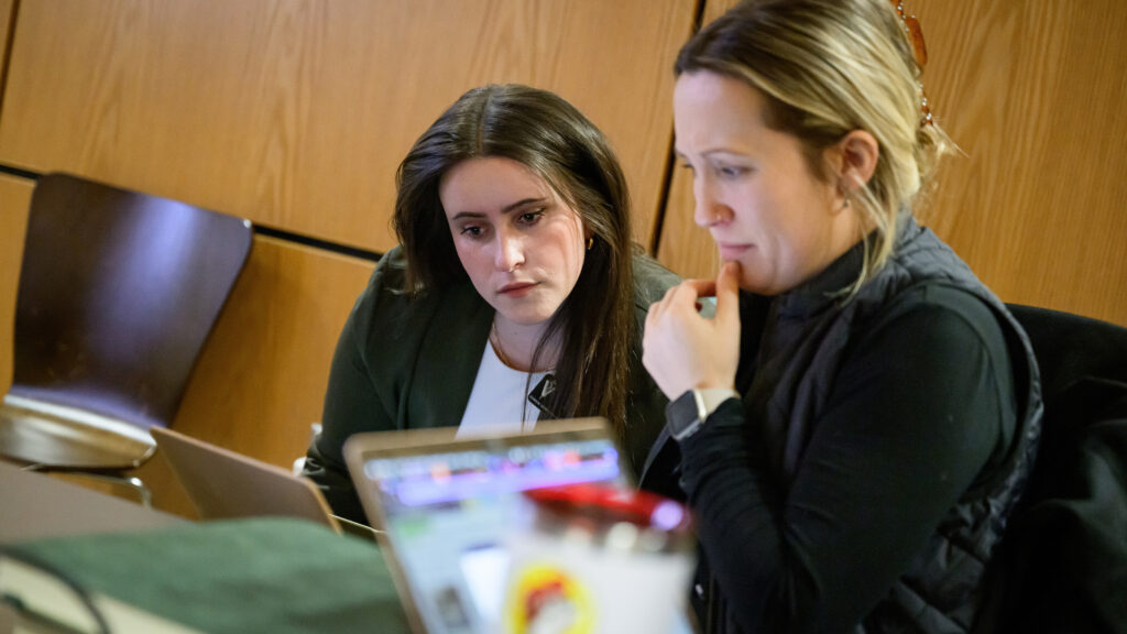 Donnell looks at a veterinarian's laptop over her shoulder.