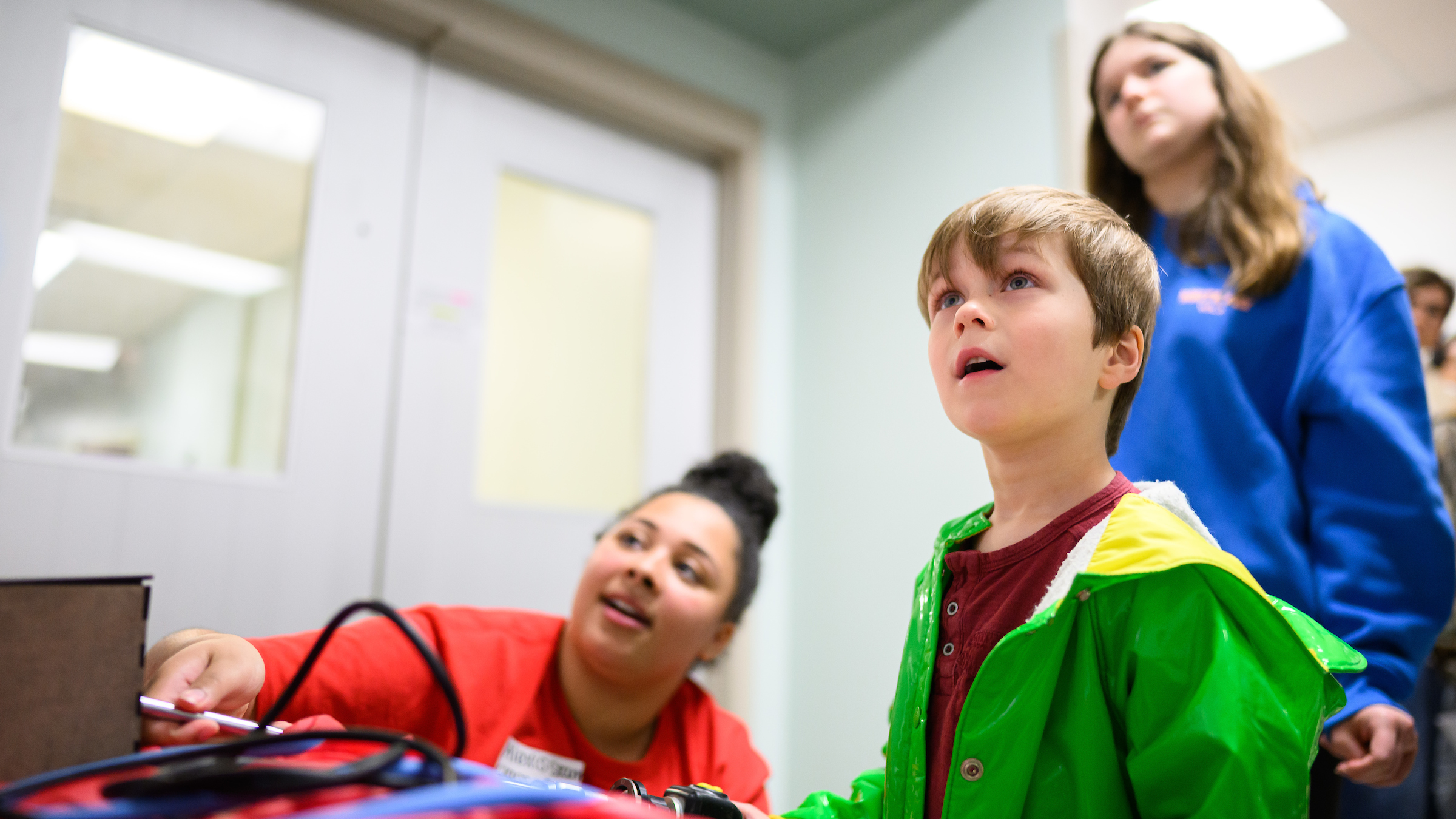 A child looks on in awe as a DVM student demonstrates a mock scoping procedure to him.