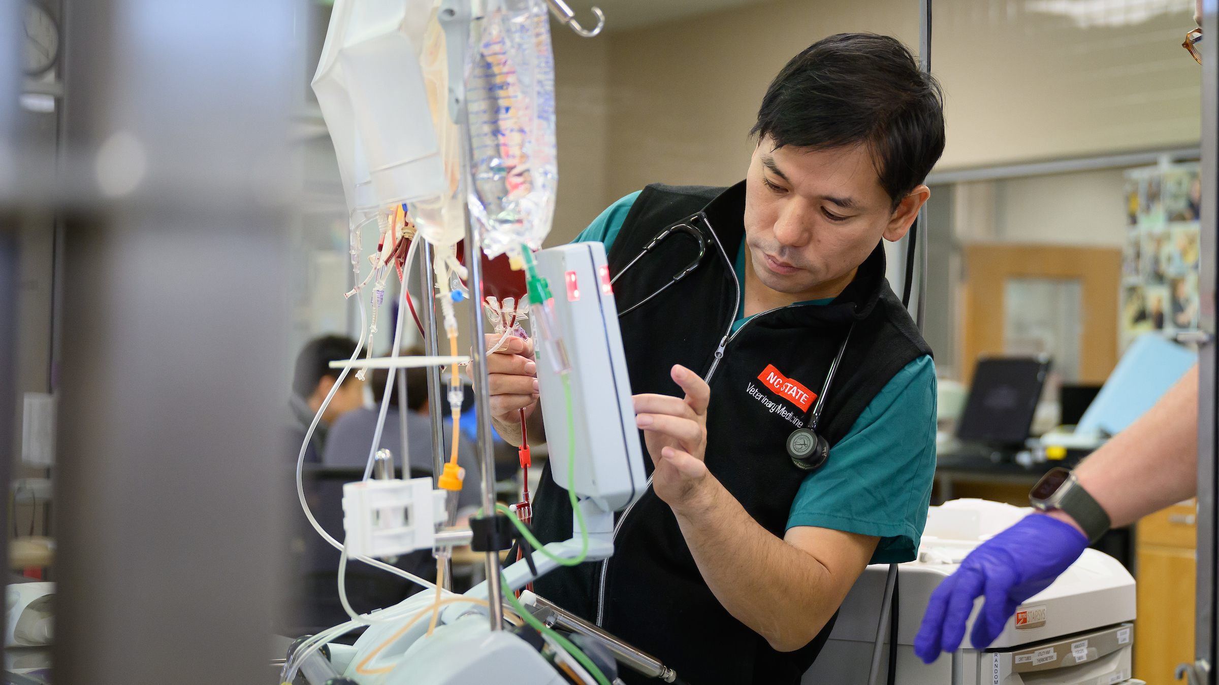 Dr. Yu Ueda adjusts a machine used in extracorporeal therapy at the NC State College of Veterinary Medicine.
