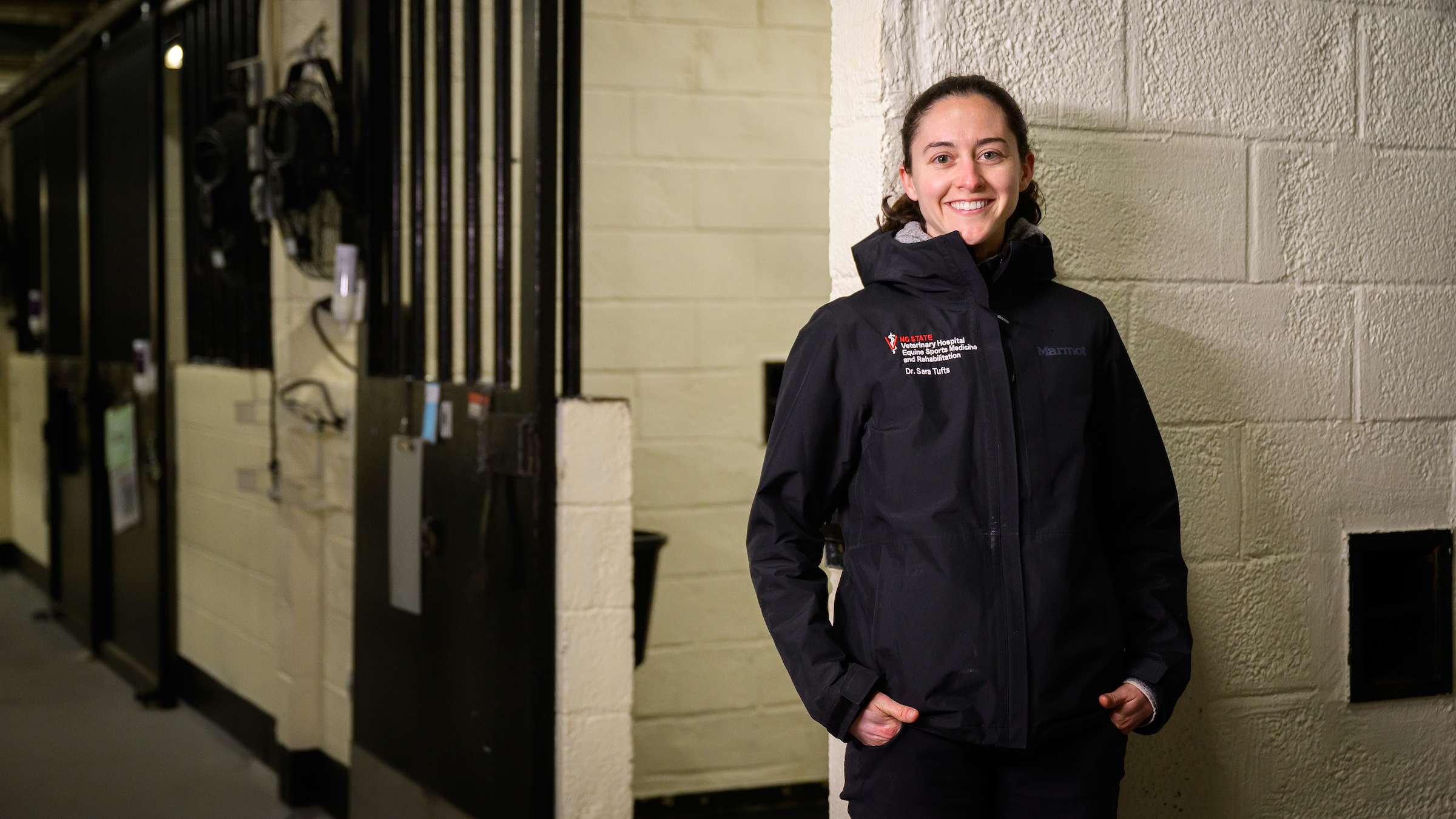 Dr. Sara Tufts stands in front of stalls at the NC State Large Animal Hospital.