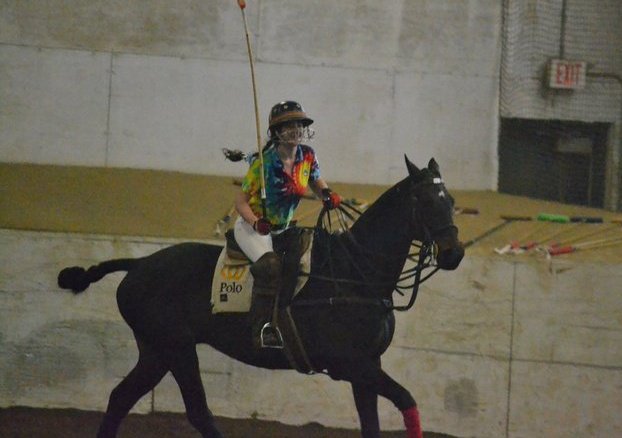 A younger Dr. Tufts rides a horse during a polo match.