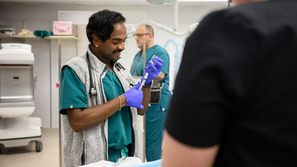 Dr. Jerome Joseph draws a dose of a drug from a bottle.