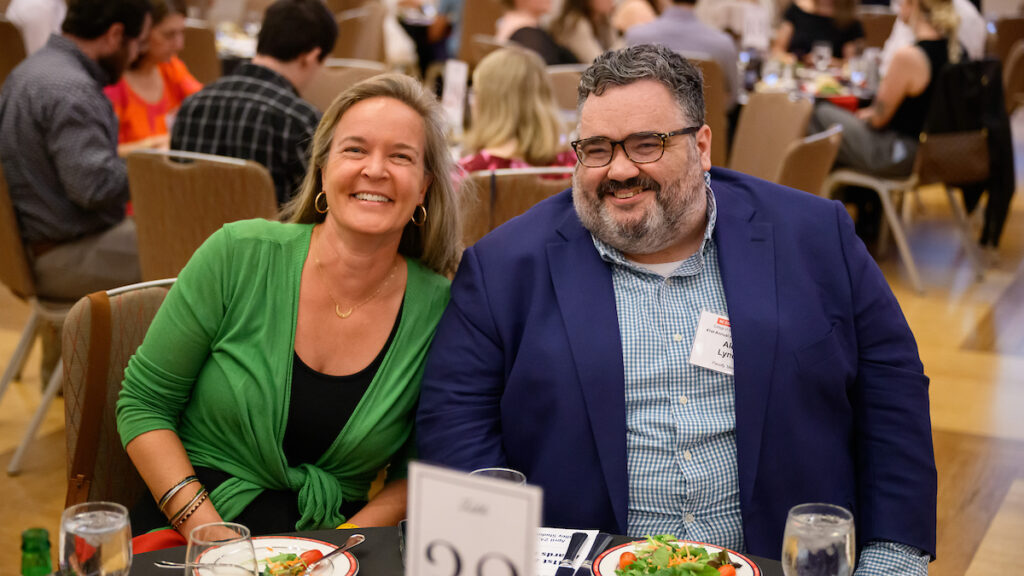 Woman in green sweater seated next to man in blue jacket.