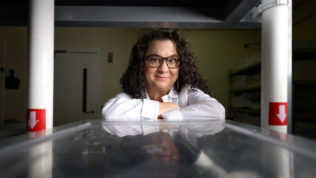 Dr. Nanette Yoder in white lab coat with arms crossed, brown glasses