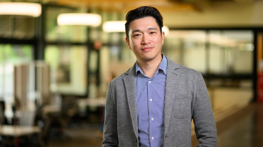 Dr. Ron Li in a navy and white striped shirt and gray jacket.